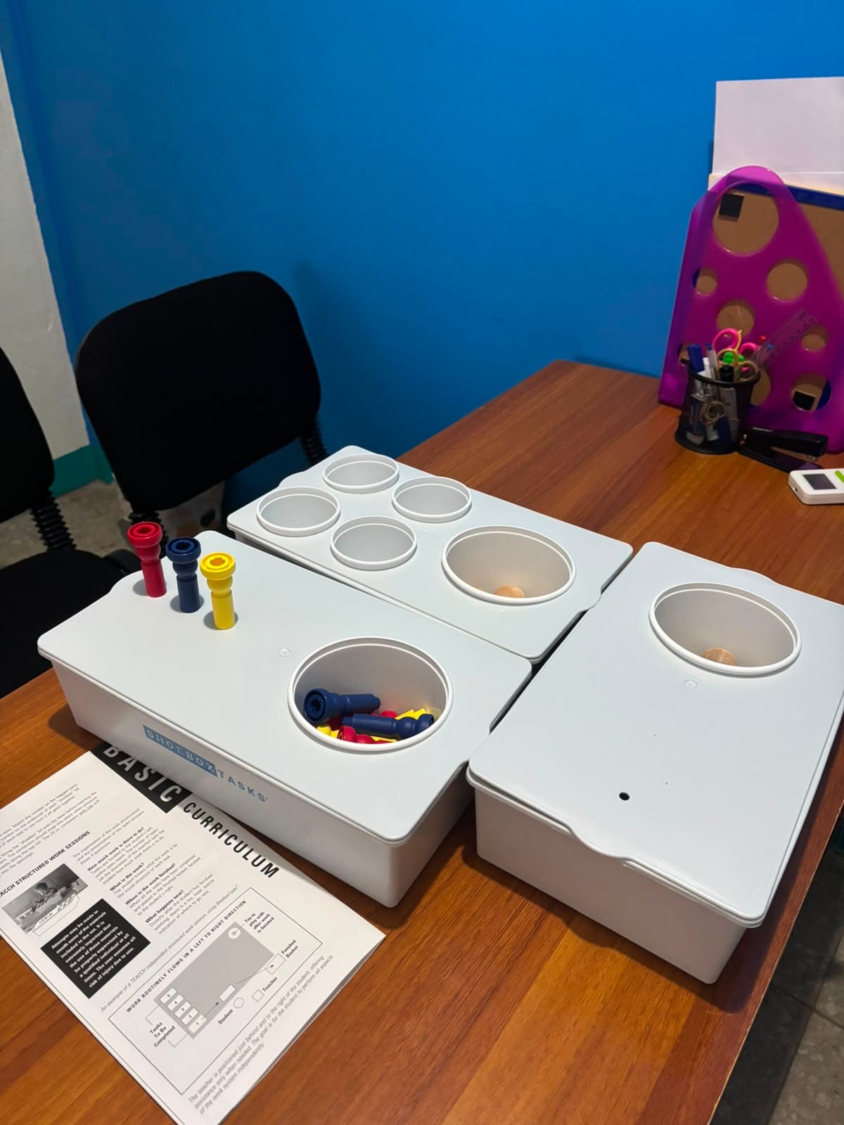 Mamá y su bebé de 18 meses sentados en una mesa de trabajo infantil, manipulando un juguete educativo en Centro Conecta - Dos.