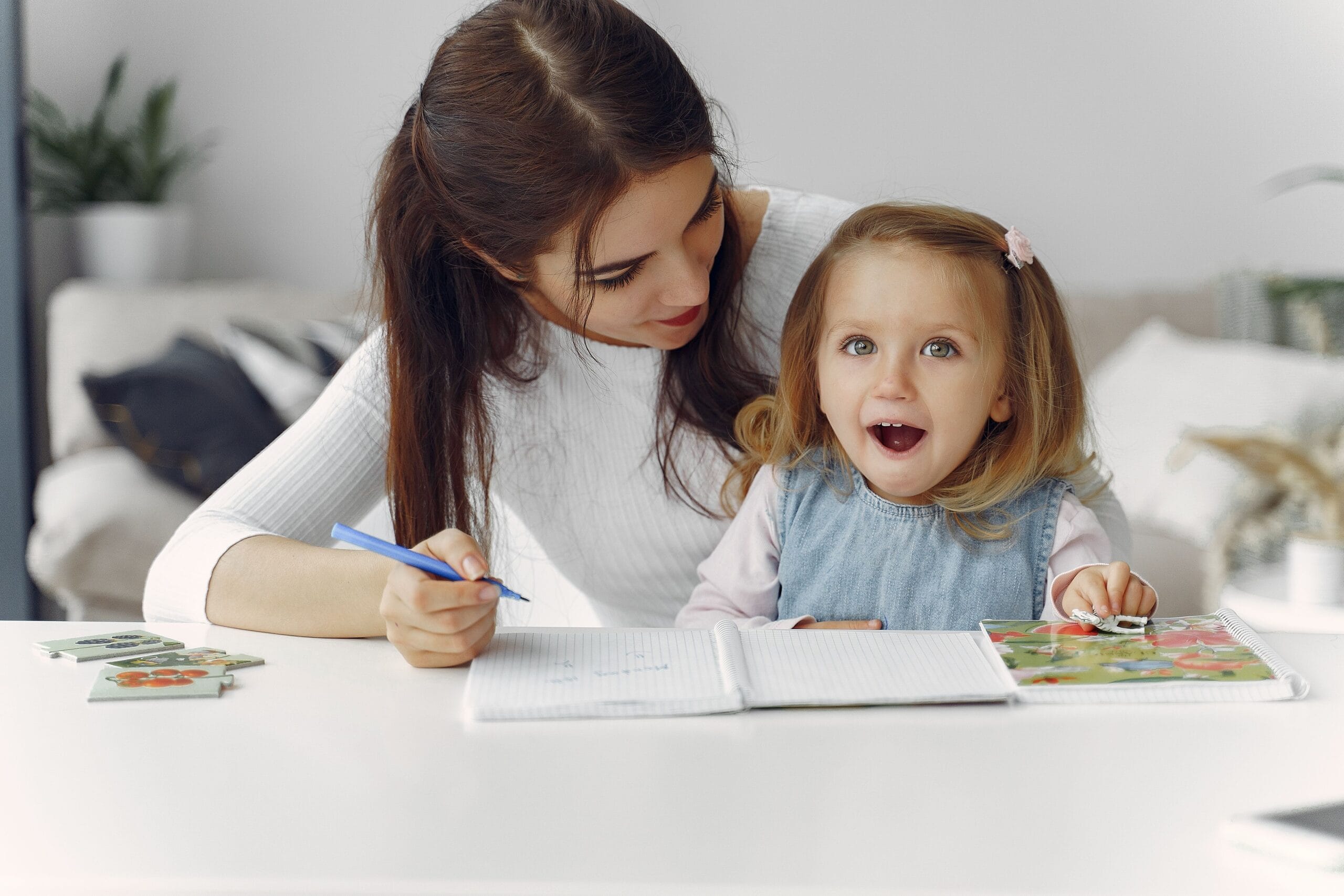 Niño de 3 años en terapia de logopedia con espejos y tarjetas de articulación para mejorar la pronunciación.
